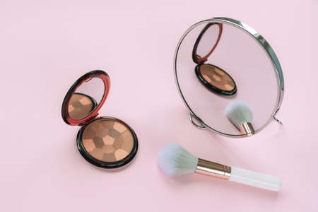 Blush, cosmetic brush and mirror on pink backgroung. Beauty, fashion concept. Top viewの写真素材