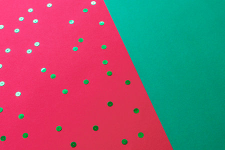 Red and green Christmas festive background with confetti. Top view, flat lay, copy spaceの写真素材