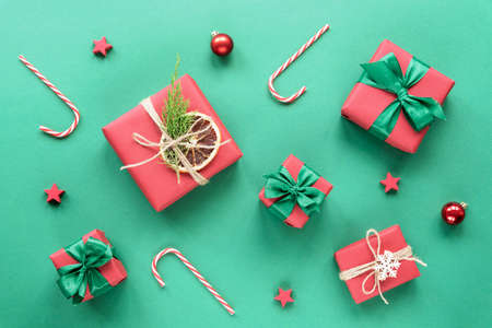 Christmas and New Year holiday background. Red gift boxes with bows on green background. Top view, flat lay.の写真素材