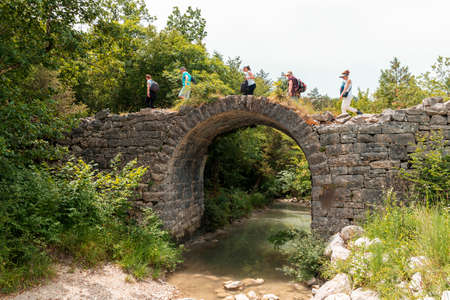 Tourists walks across the Napoleon's Bridge over the Mirna river in Istria, Croatia.の写真素材
