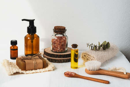 Bath accessories and natural cosmetics, himalayan pink salt in glass jar, essential oil on white background. Zero waste, aromatherapy concept.の写真素材