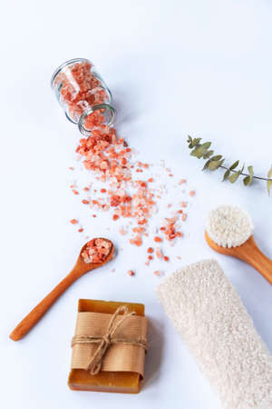 Natural cosmetics, soap, himalayan salt, face brush, towel and eucalyptus leaves on white table. Zero waste, Plastic free. Sustainable lifestyle concept. Top view. Selective focus.の写真素材