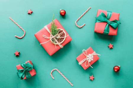Christmas and New Year holiday background. Red gift boxes with bows and Christmas balls on green background. Top view, flat layの写真素材