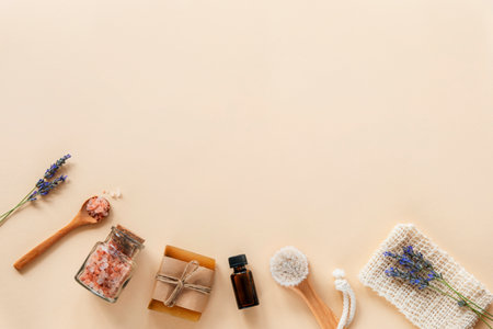 Bath accessories and natural cosmetics, himalayan pink salt in glass jar, essential oil, soap and lavender flowers on beige background. Zero waste concept. Top view, flat lay, copy spaceの写真素材