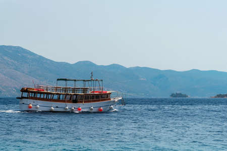 Tourist boat sails by the sea along the islands.の写真素材