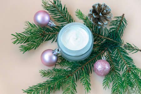Open cream jar with fir branches and Christmas balls decorative flat lay backdrop. Winter season cosmetics advertisement, top view.の写真素材