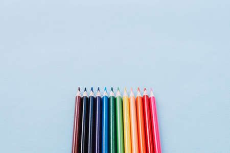 Color pencils on blue background, top view. School supplies close-up. Back to school concept. Copy space.の写真素材