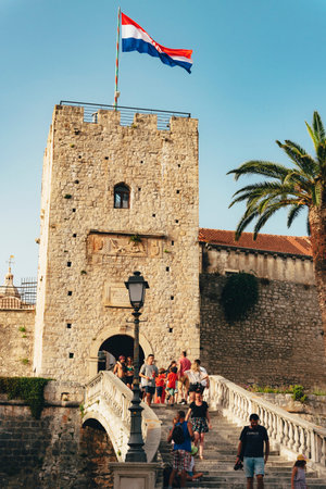Korcula Croatia - 10 August 2021: Main entrance in the old town of Korcula with walking people.のeditorial素材