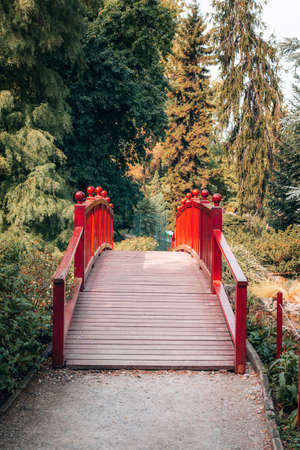 Red wooden bridge in a park. Beautiful nature.の写真素材