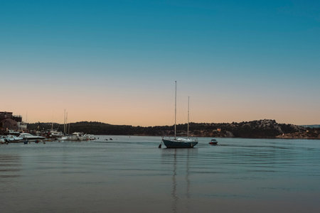 Boat in the sea against the backdrop of the seashore at sunset. Summer vacation travel concept.