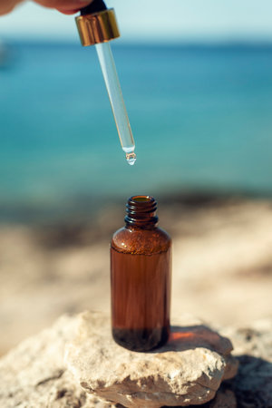Cosmetic serum bottle and pipette on the background of the sea. Closeupの写真素材