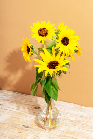 Bouquet of sunflowers in glass vase on wooden table. Closeup.の写真素材