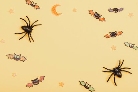Halloween festive background with spiders and bats on yellow. Top view, flat lay, copy space.の写真素材