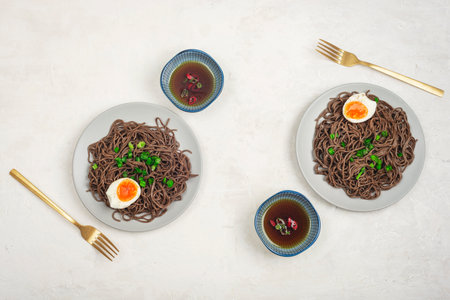Soba noodles with egg, green onion and spicy sauce on white table. Asian food. Top view, flat lay.の写真素材