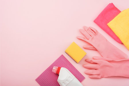 Home cleaning concept, housecleaning, hygiene, chores, cleaning supplies. Cleaning agent, rag, sponge and gloves on pink background. Top view, flat lay, copy spaceの写真素材