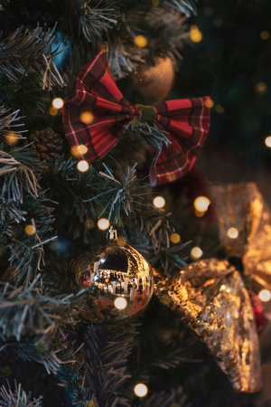 Christmas decorations on fir tree with golden and red balls and Christmas lights, closeupの写真素材