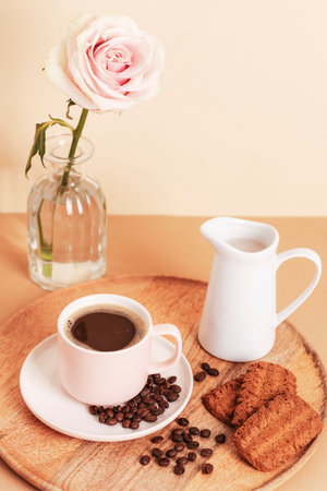 Coffee cup, cookies and jug with milk on a wooden tray. Morning breakfast concept.の写真素材