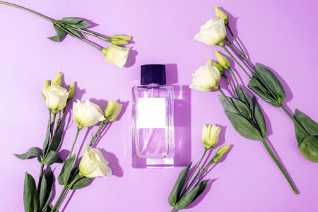 Purple perfume bottle and white eustoma flowers in sunlight. Top view, flat lay, mockup.の写真素材