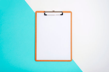 Clipboard with blank paper on blue and white background. Top view, flat lay, mockupの写真素材