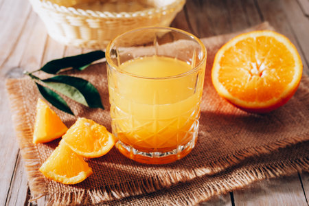 Orange juice on sackcloth napkin on wooden table. Healthy drink. Closeupの写真素材