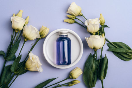 Purple cosmetic bottle and white eustoma flowers. Top view, flat lay.の写真素材