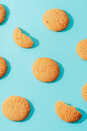 Homemade cookies on blue background with sharp shadows. Top view, flat lay.の写真素材