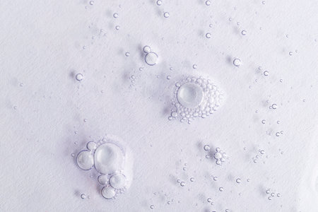 Close up macro cosmetic gel serum texture on white background with bubbles. Natural skincare product. Antibacterial liquid, moisturizing. Top view.の写真素材