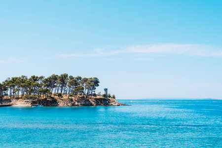 Small rocky island with lighthouse on the Rajska beach on the Rab island in Croatia.の写真素材