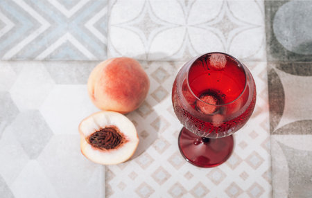 Glass with cold drink and peaches on vintage tile background. Top view. Selective focus.の写真素材