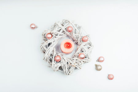 Christmas wreath with pink candle and balls on silver gray background. Winter holidays concept. Top view, flat lay.の写真素材