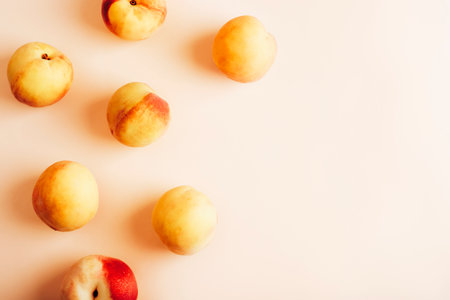 Ripe fresh peaches on light pink background. Top view, flat lay, copy space.の写真素材