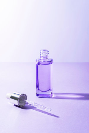 Cosmetic serum with dropper on purple background. Skin care concept. Closeup.の写真素材