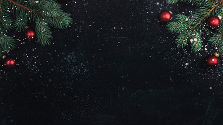 Christmas tree branches and red balls on black background with snow. New Year concept. Top view, flat lay, copy space.の写真素材
