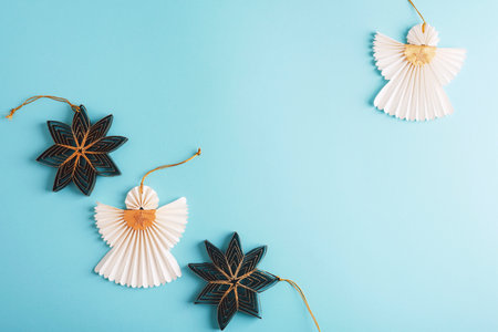 Paper angels and fir tree toys on blue background. Christmas concept. Top view, flat lay, copy space.の写真素材