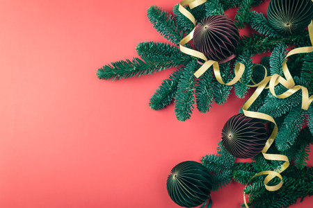 Paper fir tree toys and branches with golden tinsel on red background. Christmas concept. Top view, flat lay, copy space.の写真素材