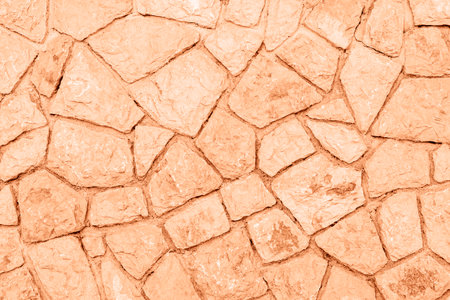 Old grunge stone wall background, texture. Demonstrating color of the year 2024 Peach Fuzz.の写真素材
