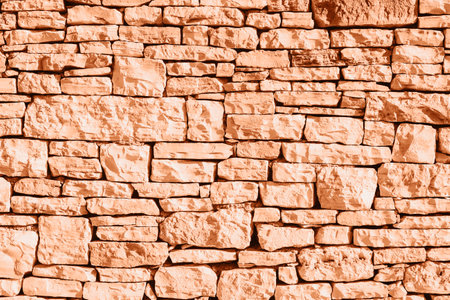 Old grunge stone masonry background, texture. Demonstrating color of the year 2024 Peach Fuzz.の写真素材
