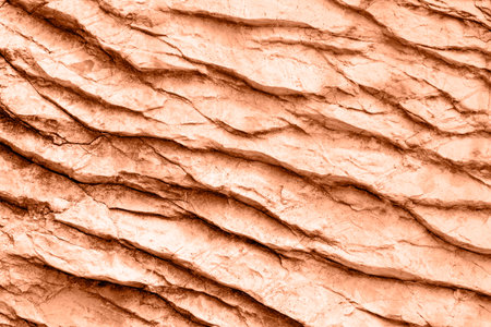 Peachy rock or stone surface. Background, texture. Color of the year 2024 - Peach Fuzz.の写真素材