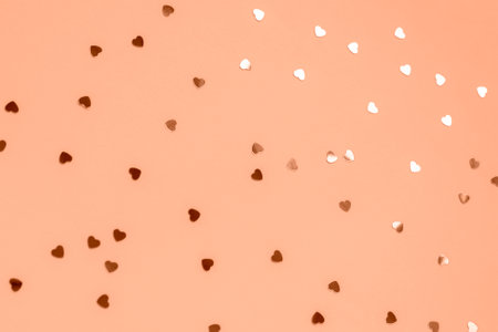 Peach Fuzz color festive background with confetti, texture. Selective focus.の写真素材