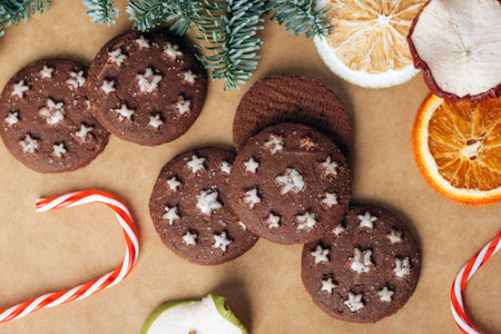 Christmas gingerbreads, candy cane, dried fruits and baubles on kraft paper background. Top view, flat layの写真素材