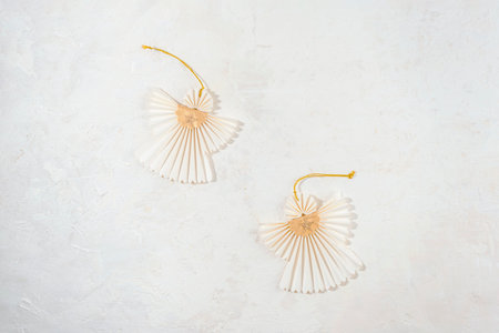 Two Christmas paper angels on white textured background. Top view, flat lay.の写真素材