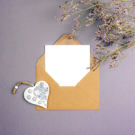 Envelope with blank card, vintage toy heart and flowers on gray background. Valentines day, womens day concept, top view, flat lay, mockup.の写真素材