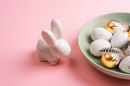 Easter layout with plate of Easter eggs and bunny on pink table. Top view.の写真素材