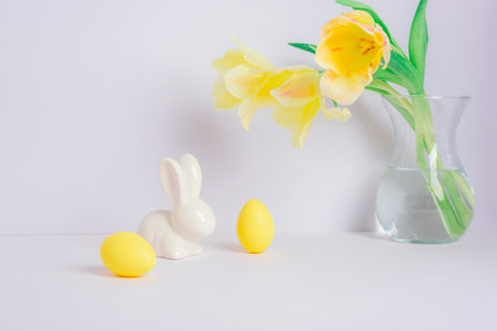 Yellow tulips in vase and Easter decorations on white background. Easter conceptの写真素材