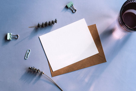 Envelope with blank card and lavender flowers on purple background. Top view, flat lay, mockup.の写真素材