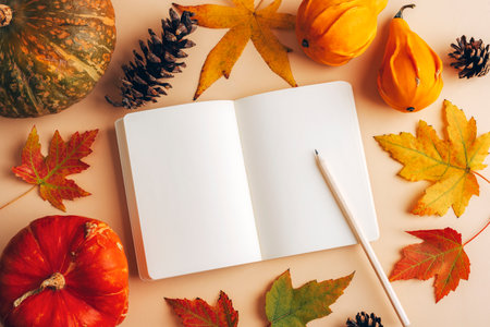 Blank open notepad with pencil, autumn leaves and pumpkins. Thanksgiving concept. Top view, flat lay, mockupの写真素材