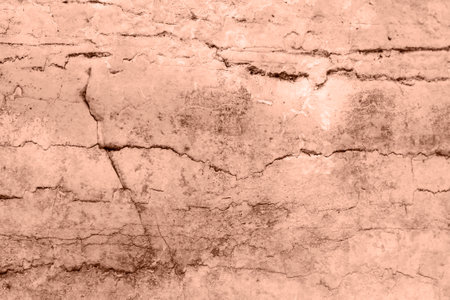 Closeup of a cracked stone wall with a brown brick pattern. Texture, background. Demonstrating color of the year 2025 - Mocha Mousseの写真素材
