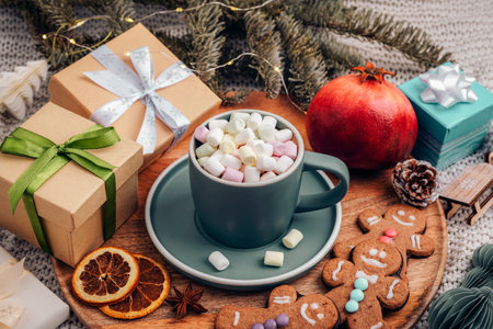 Flat lay of hot cocoa with marshmallows surrounded by Christmas gifts, gingerbread cookies, and festive decorations. Top view.の写真素材
