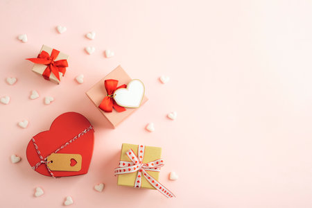 Gift boxes with red and pink hearts on a pastel pink background. Valentine's Day celebrations. Top view, flat lay, copy space.の写真素材