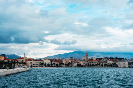 Coastal cityscape with mountains and cloudy sky over blue sea. Split, Croatiaの写真素材